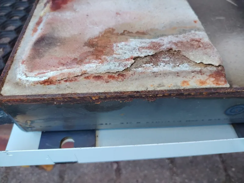 Cracked and crumbling ceramic insulation board on the burner door of a Grant Vortex Pro oil boiler