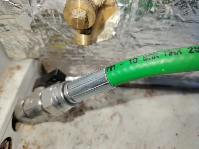 Old flexible braided oil supply hose on a Grant Vortex Pro burner, rated 10 bar maximum, replaced during a service in Shillingford St George