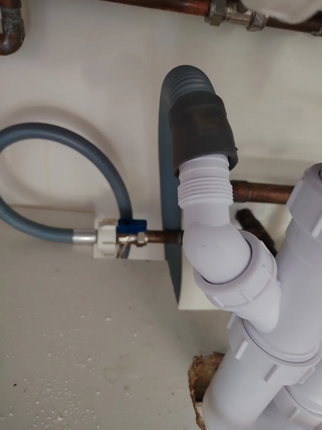 Old kitchen waste pipework and failed trap being removed under the sink