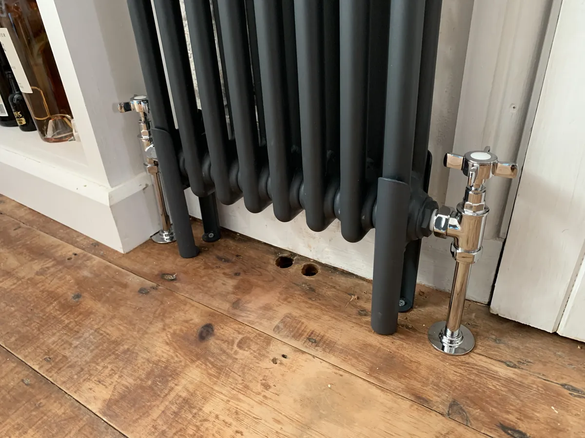 Chrome valves on a column radiator over an oak floor, Exeter