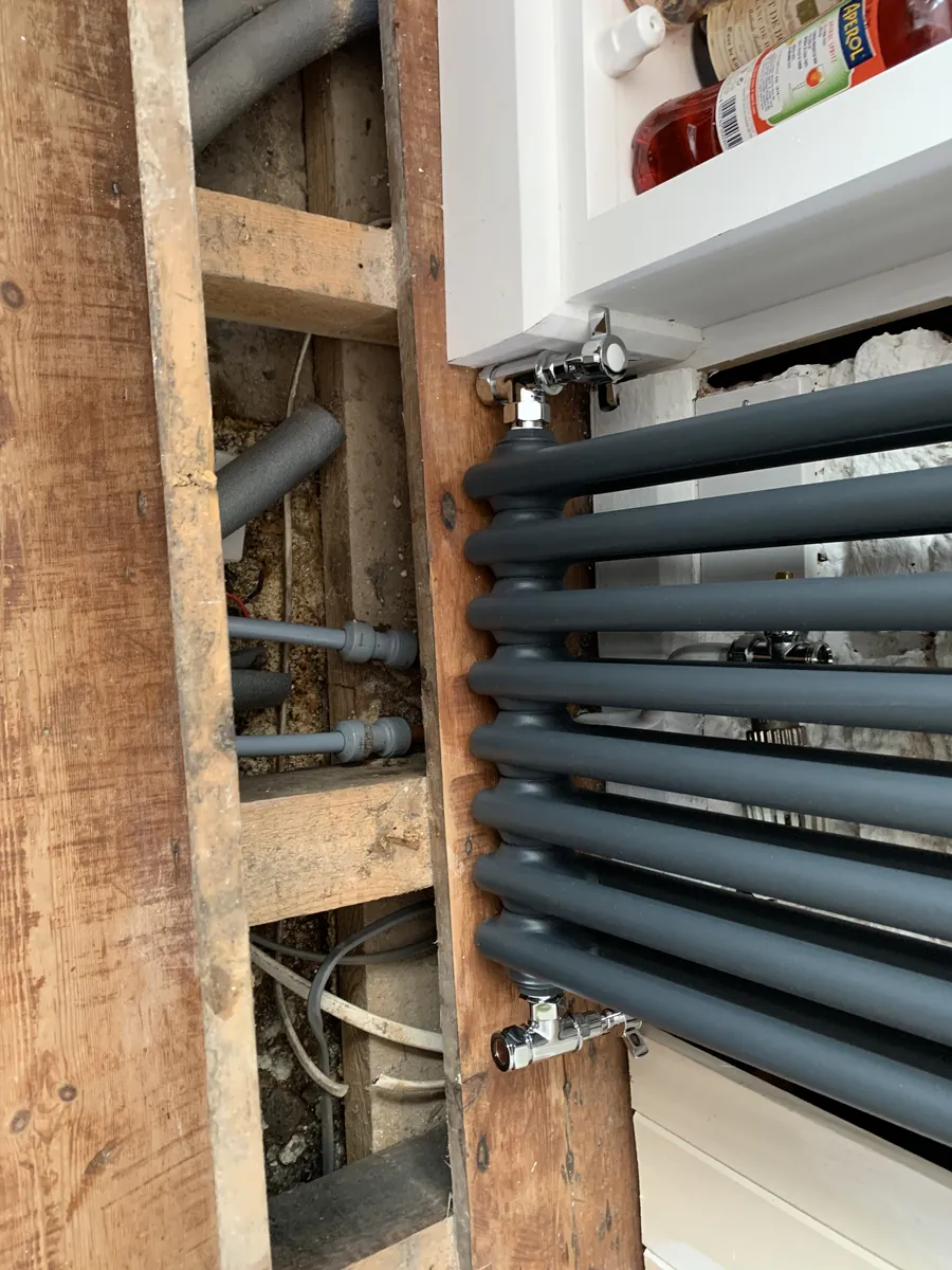 Radiator pipework run under the floorboards during an installation in Exeter