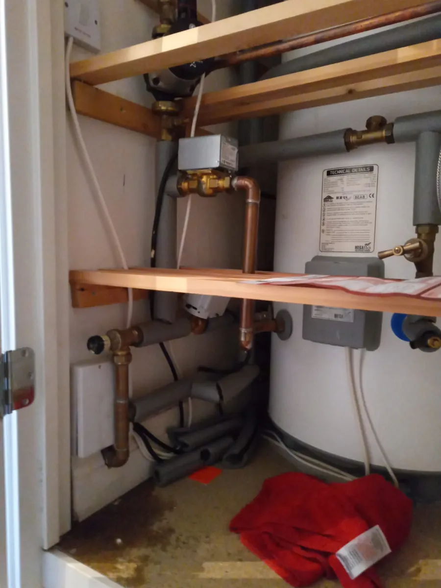 New hot water cylinder installation with pipework in a Devon airing cupboard