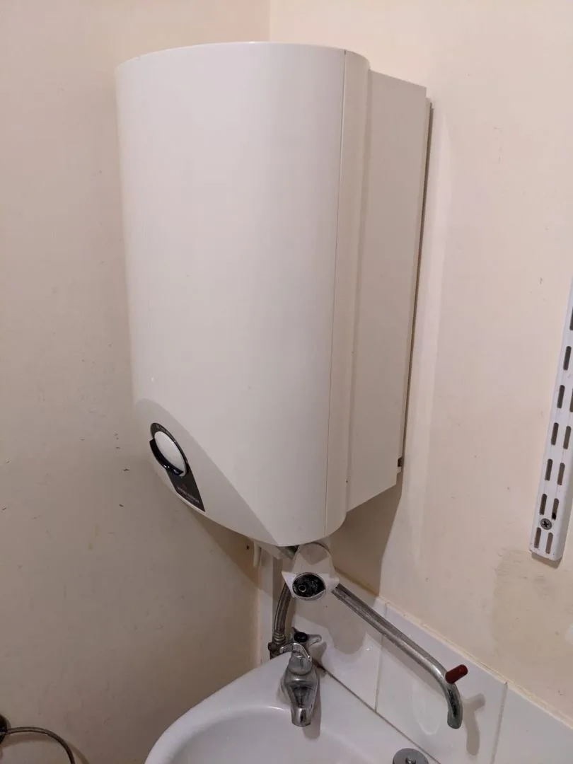 Wall-hung electric water heater installed above the staff basin at Saltrock, Sidmouth